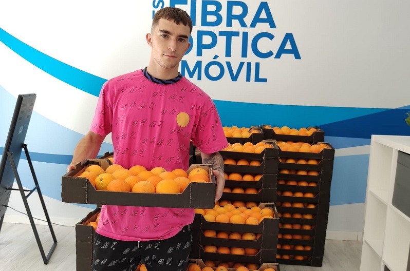 Cliente con naranjas regaladas por Avanza Fibra.