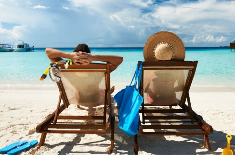 Dos personas toman el sol en una playa. Dos personas toman el sol en una playa.