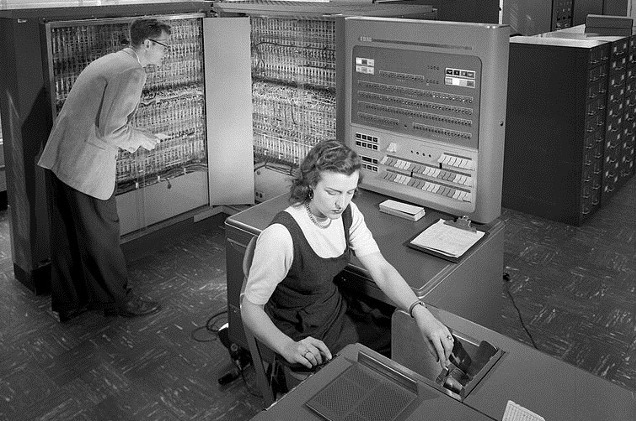 Una mujer trabaja con un mainframe de IBM. Una mujer trabaja con un mainframe de IBM.
