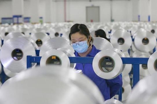 Una operaria se protege del coronavirus en una fábrica. Una operaria se protege del coronavirus en una fábrica.