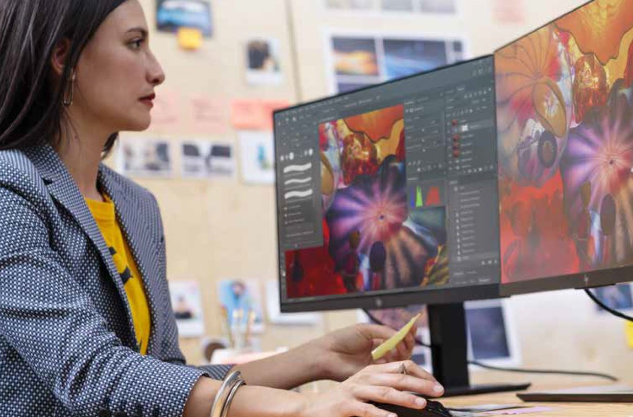 Una mujer trabaja con dos monitores. Una mujer trabaja con dos monitores.